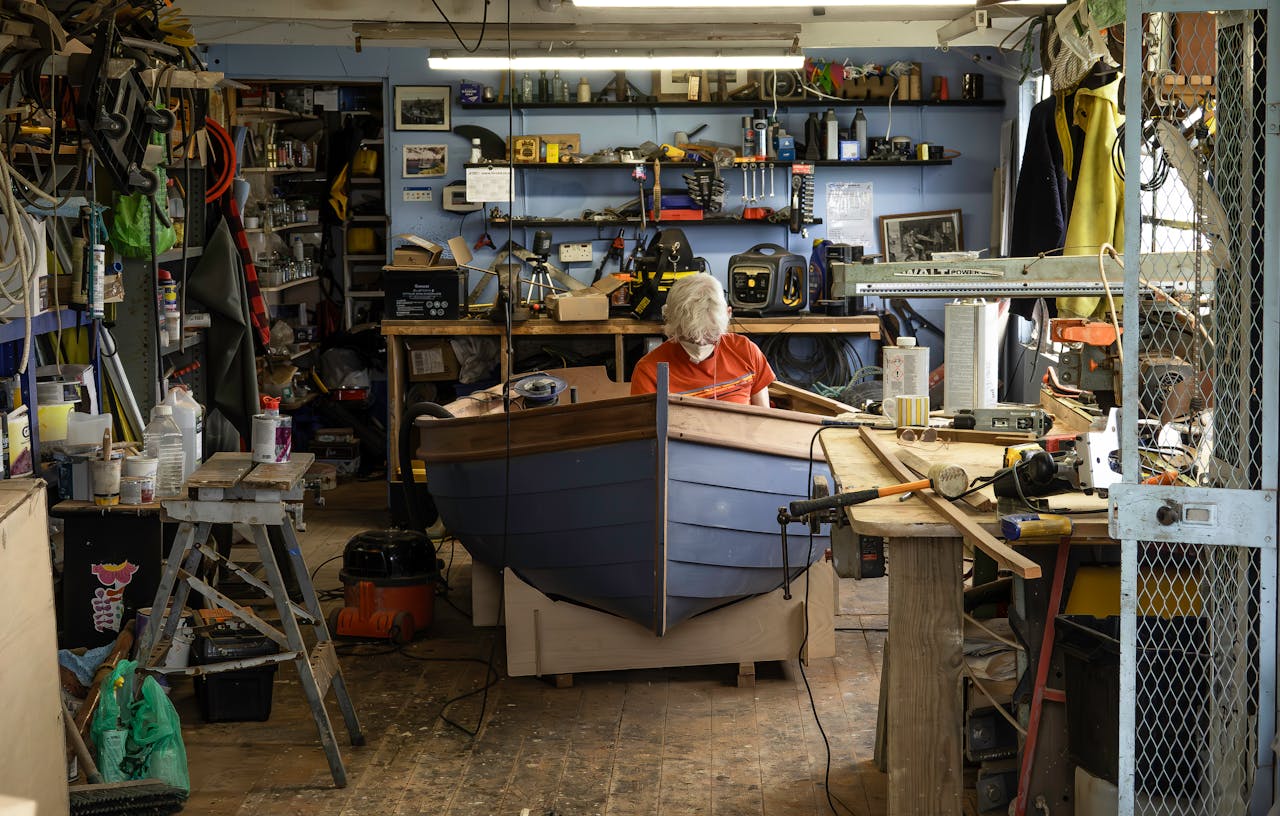 services-03 A craftsman focusing on boat building in a cluttered workshop at Dell Quay, England.